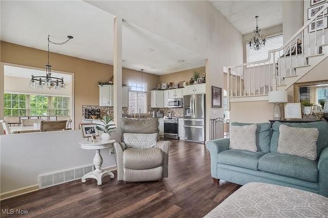 8550 Ivy Hill Dr Unit 16, Poland, OH 44514 - living area featuring a chandelier, dark wood-style flooring, plenty of natural light, and a towering ceiling