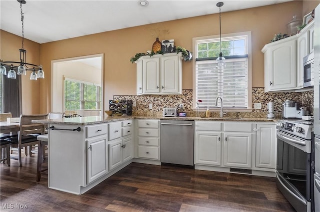 8550 Ivy Hill Dr Unit 16, Poland, OH 44514 - kitchen with stainless steel appliances, a peninsula, a sink, white cabinetry, and a chandelier