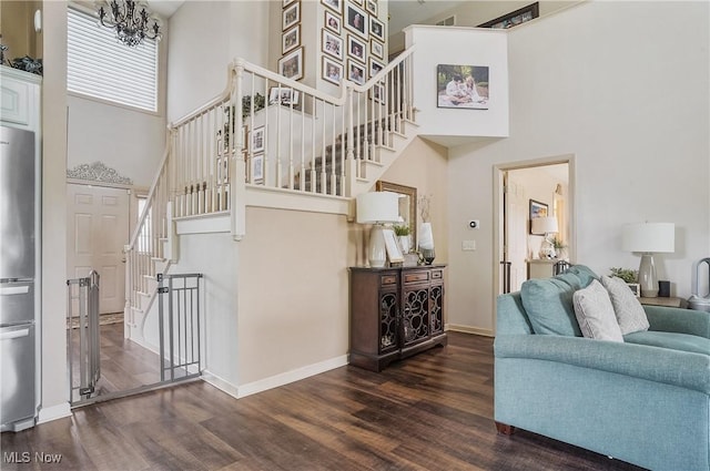 8550 Ivy Hill Dr Unit 16, Poland, OH 44514 - living room featuring a high ceiling, wood finished floors, stairway, baseboards, and a chandelier