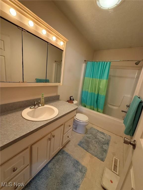 6920 Riverside Rd SE, Gnadenhutten, OH 44629 - full bath with shower / bath combo with shower curtain, vanity, toilet, a textured ceiling, and tile patterned flooring