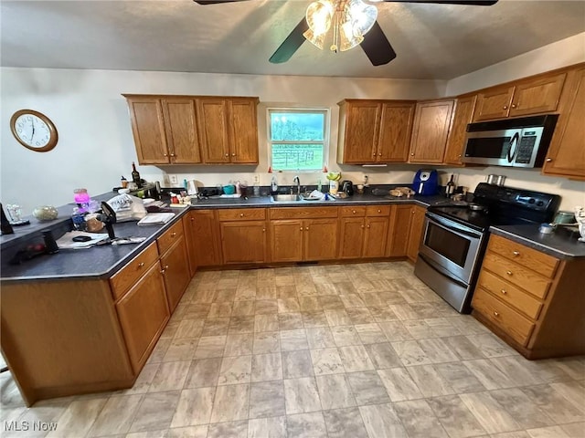6920 Riverside Rd SE, Gnadenhutten, OH 44629 - kitchen with appliances with stainless steel finishes, a sink, brown cabinetry, a ceiling fan, and dark countertops