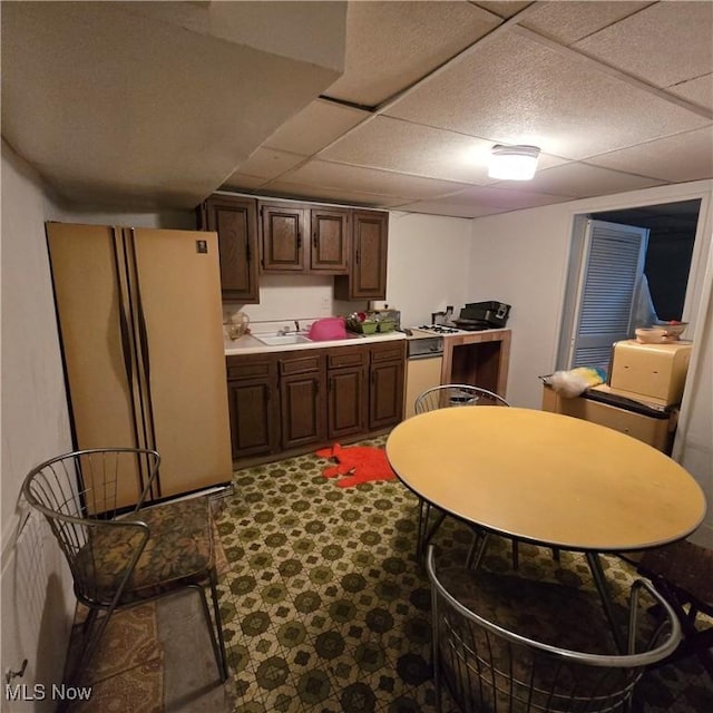 1669 Wood Rd, Cleveland Heights, OH 44121 - kitchen with light countertops, dark brown cabinets, a sink, a paneled ceiling, and freestanding refrigerator