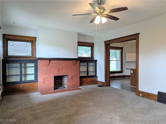 925 Camden Ave SW, Canton, OH 44706 - unfurnished living room with carpet, a brick fireplace, baseboards, and a ceiling fan