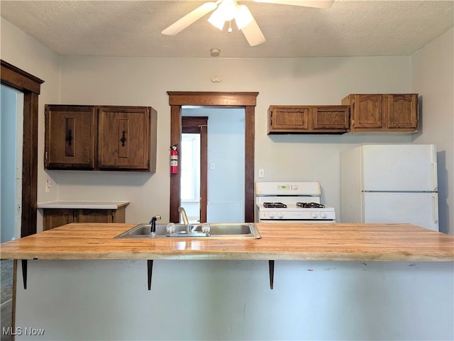 925 Camden Ave SW, Canton, OH 44706 - kitchen with white appliances, a sink, a kitchen bar, ceiling fan, and butcher block countertops