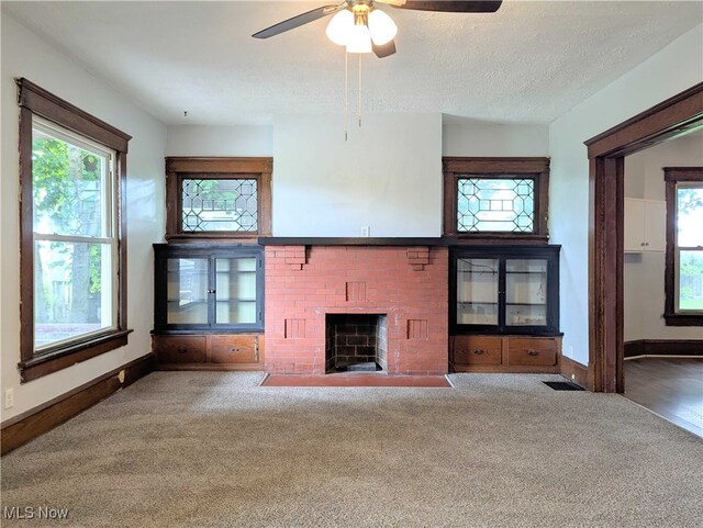 925 Camden Ave SW, Canton, OH 44706 - unfurnished living room featuring a brick fireplace, carpet flooring, baseboards, and a textured ceiling