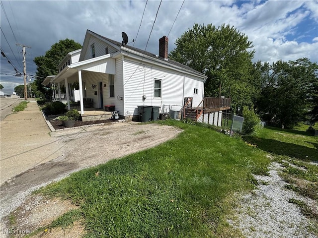 208 Walton Ave, Barnesville, OH 43713 - back of house with covered porch, a chimney, and a yard