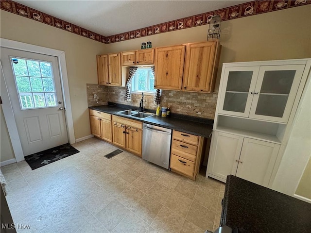 208 Walton Ave, Barnesville, OH 43713 - kitchen with stainless steel dishwasher, a sink, dark countertops, decorative backsplash, and baseboards