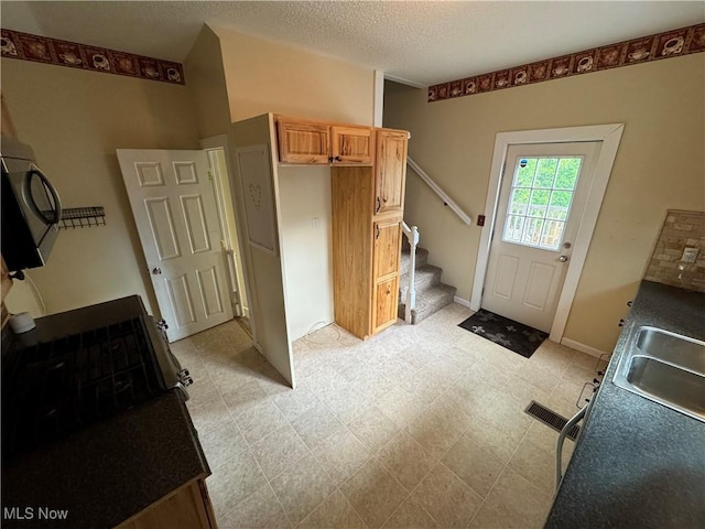 208 Walton Ave, Barnesville, OH 43713 - mudroom with a sink, light floors, a textured ceiling, and baseboards