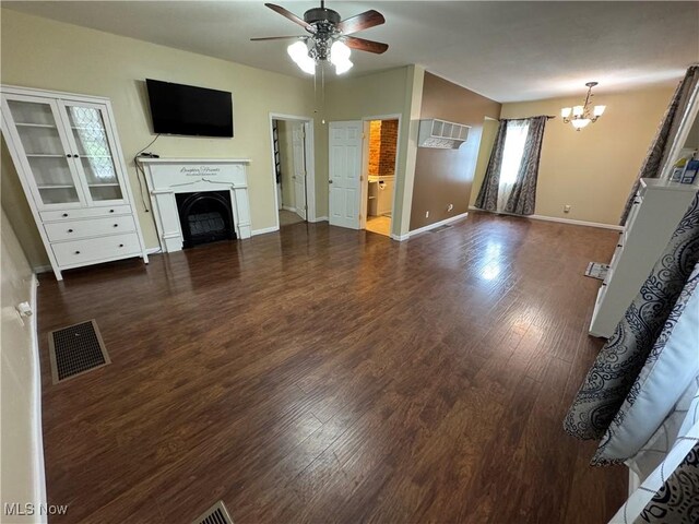 208 Walton Ave, Barnesville, OH 43713 - unfurnished living room with a chandelier, ceiling fan, a fireplace, wood finished floors, and a wall unit AC
