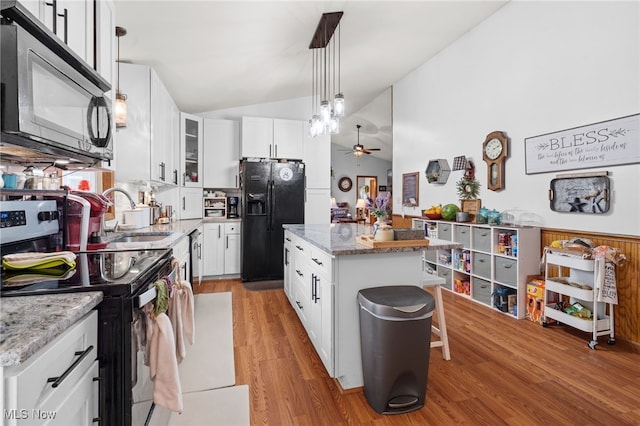4948 State Route 61, Mount Gilead, OH 43338 - kitchen with electric range, black refrigerator with ice dispenser, vaulted ceiling, a sink, and light wood-style floors
