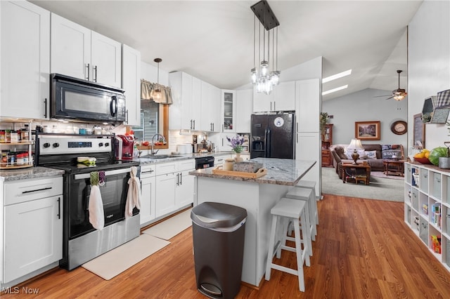 4948 State Route 61, Mount Gilead, OH 43338 - kitchen featuring black appliances, a sink, a kitchen island, lofted ceiling, and tasteful backsplash