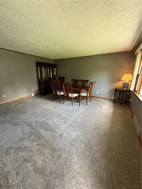 1414 W 40th St, Lorain, OH 44053 - dining area with a textured ceiling, carpet floors, and baseboards