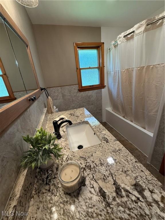 1414 W 40th St, Lorain, OH 44053 - full bath with shower / bath combo, vanity, and tile walls