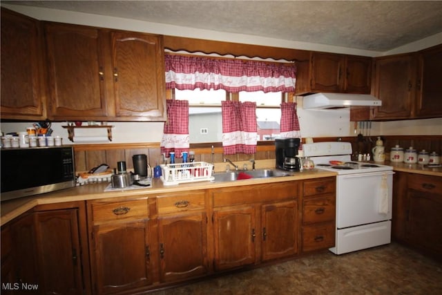 14201 Kauffman Ave, Sterling, OH 44276 - kitchen featuring white range with electric stovetop, under cabinet range hood, a sink, light countertops, and brown cabinets