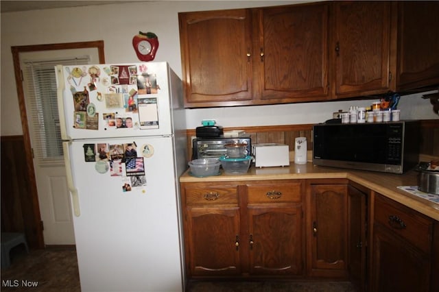 14201 Kauffman Ave, Sterling, OH 44276 - kitchen featuring freestanding refrigerator, light countertops, and a wainscoted wall