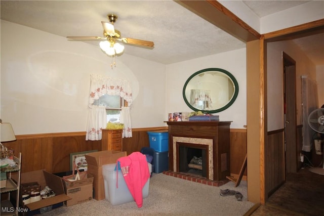 14201 Kauffman Ave, Sterling, OH 44276 - carpeted living area with a wainscoted wall, wooden walls, ceiling fan, and a fireplace
