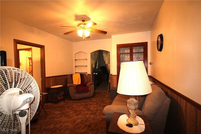14201 Kauffman Ave, Sterling, OH 44276 - living area featuring a wainscoted wall, built in features, wooden walls, ceiling fan, and carpet flooring