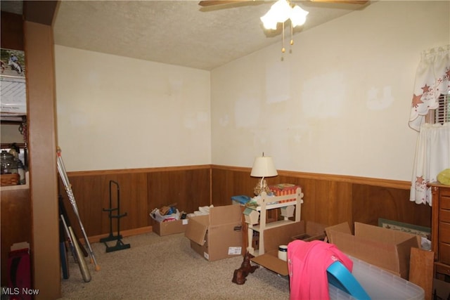 14201 Kauffman Ave, Sterling, OH 44276 - rec room featuring wainscoting, a ceiling fan, wood walls, carpet flooring, and a textured ceiling