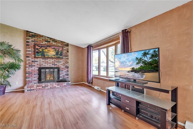 6221 Brighton Dr, North Olmsted, OH 44070 - living room with wood finished floors, lofted ceiling, a fireplace, and baseboards