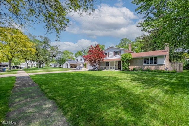 6221 Brighton Dr, North Olmsted, OH 44070 - view of front of home featuring a chimney, a front lawn, driveway, and covered porch