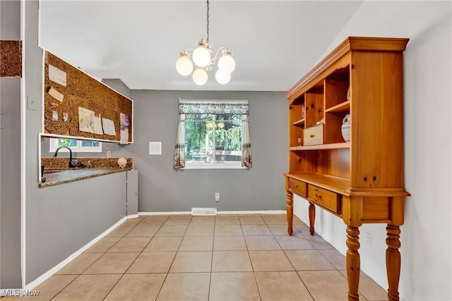 6221 Brighton Dr, North Olmsted, OH 44070 - unfurnished dining area with a chandelier, baseboards, light tile patterned flooring, and a sink