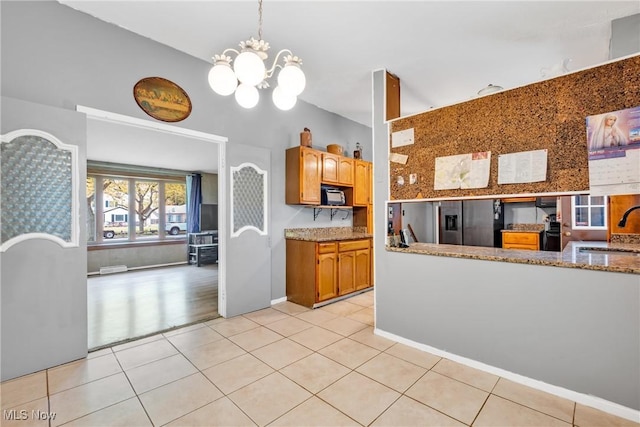 6221 Brighton Dr, North Olmsted, OH 44070 - kitchen with a chandelier, a sink, light tile patterned flooring, fridge with ice dispenser, and black microwave