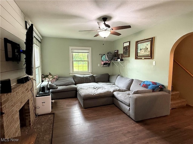 7350 Center Rd, Saybrook, OH 44004 - living area with arched walkways, wood finished floors, a ceiling fan, stairs, and a textured ceiling