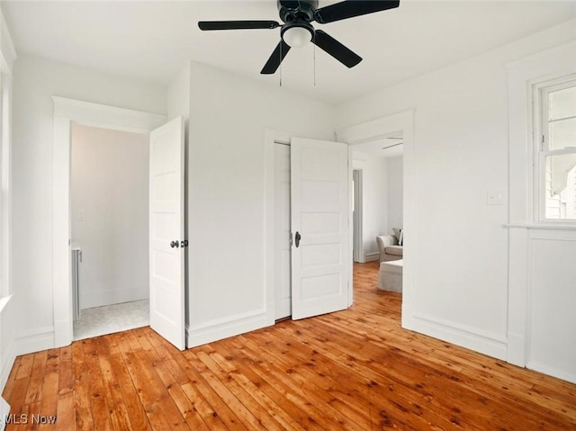 1433 W 4th St, Ashtabula, OH 44004 - unfurnished bedroom featuring light wood-style flooring, ceiling fan, and baseboards