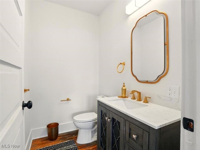 1433 W 4th St, Ashtabula, OH 44004 - half bath featuring wood finished floors, vanity, toilet, and baseboards