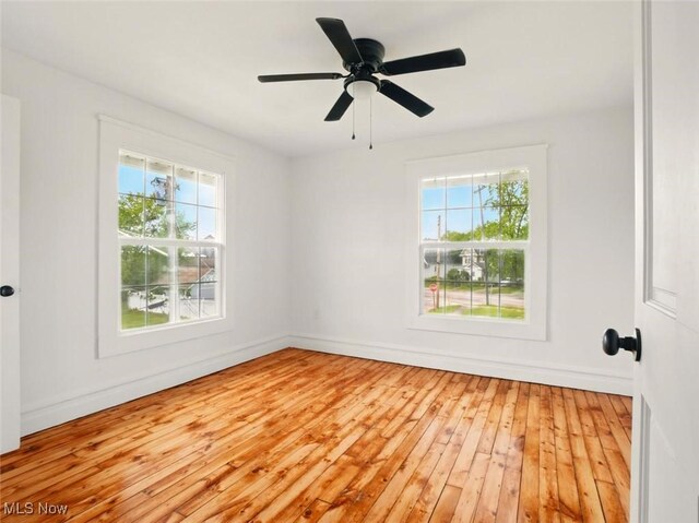 1433 W 4th St, Ashtabula, OH 44004 - empty room with healthy amount of natural light, light wood finished floors, and baseboards