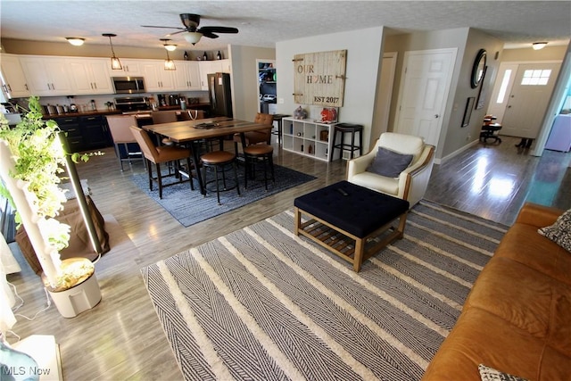 615 Wolf Ave, Wadsworth, OH 44281 - dining space with light wood-style flooring, ceiling fan, baseboards, and a textured ceiling