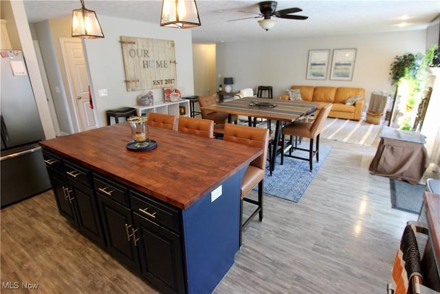 615 Wolf Ave, Wadsworth, OH 44281 - kitchen featuring fridge, wood counters, light wood-style floors, open floor plan, and ceiling fan