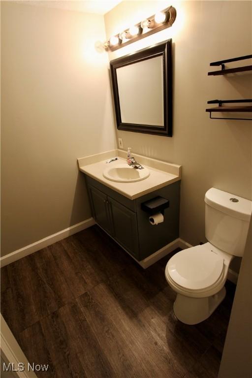 615 Wolf Ave, Wadsworth, OH 44281 - bathroom featuring vanity, wood finished floors, toilet, and baseboards