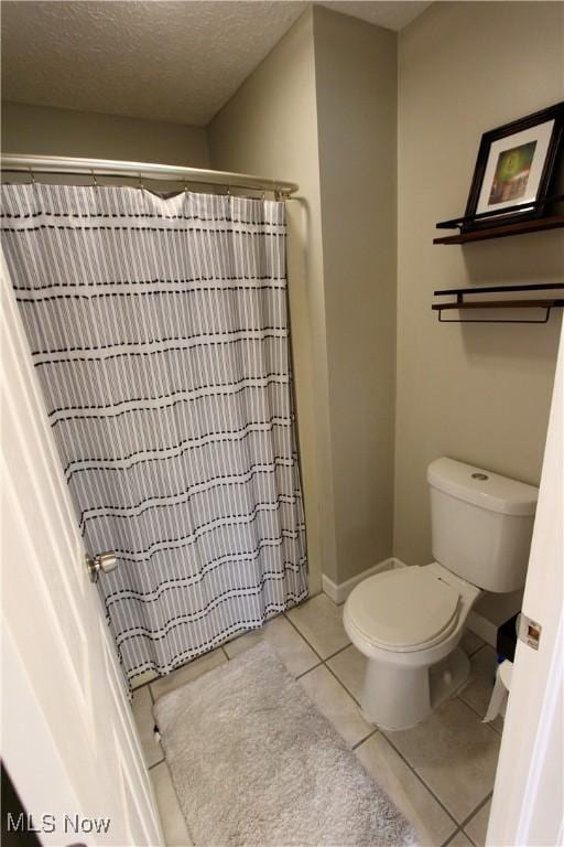 615 Wolf Ave, Wadsworth, OH 44281 - full bath with tile patterned floors, toilet, a shower with shower curtain, and a textured ceiling