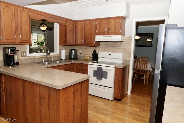5430 Barkwood Dr, Sheffield Village, OH 44054 - kitchen featuring white range with electric stovetop, under cabinet range hood, a sink, freestanding refrigerator, and a ceiling fan