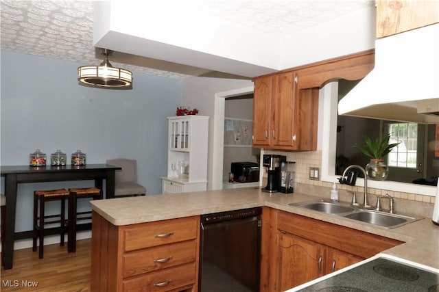 5430 Barkwood Dr, Sheffield Village, OH 44054 - kitchen featuring a sink, black dishwasher, a peninsula, light countertops, and a textured ceiling