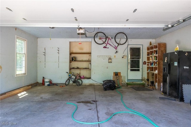 12793 New London Eastern Rd, Spencer, OH 44275 - garage with black refrigerator with ice dispenser and a garage door opener