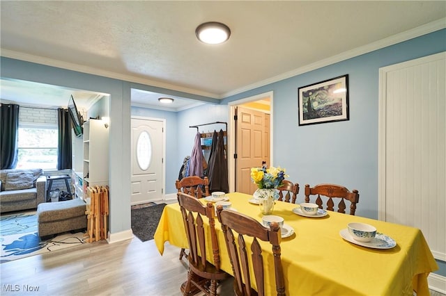 1050 W Main Ct, Geneva, OH 44041 - dining space featuring ornamental molding, light wood-style floors, healthy amount of natural light, and baseboards