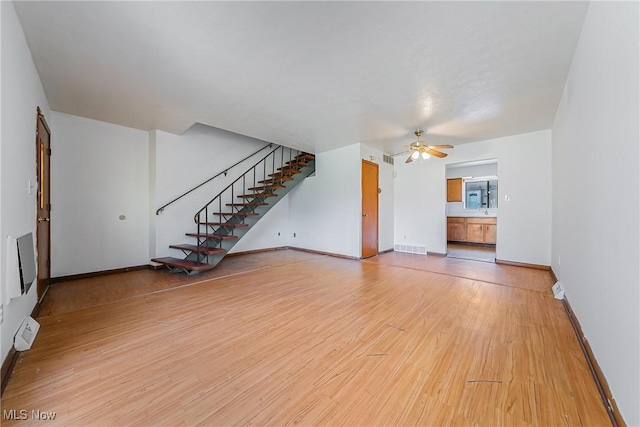 27701 Mills Ave Unit 2N, Euclid, OH 44132 - unfurnished living room with ceiling fan, light wood-type flooring, stairs, and baseboards