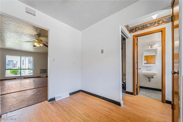 27701 Mills Ave Unit 2N, Euclid, OH 44132 - spare room featuring light wood-style floors, baseboards, ceiling fan, and a sink