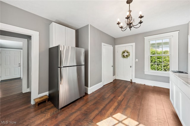 6813 W Clinton Ave, Cleveland, OH 44102 - kitchen with freestanding refrigerator, a chandelier, baseboards, dark wood-style floors, and white cabinets