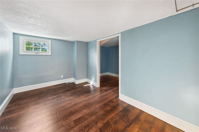6813 W Clinton Ave, Cleveland, OH 44102 - unfurnished room featuring dark wood-style flooring, baseboards, and a textured ceiling