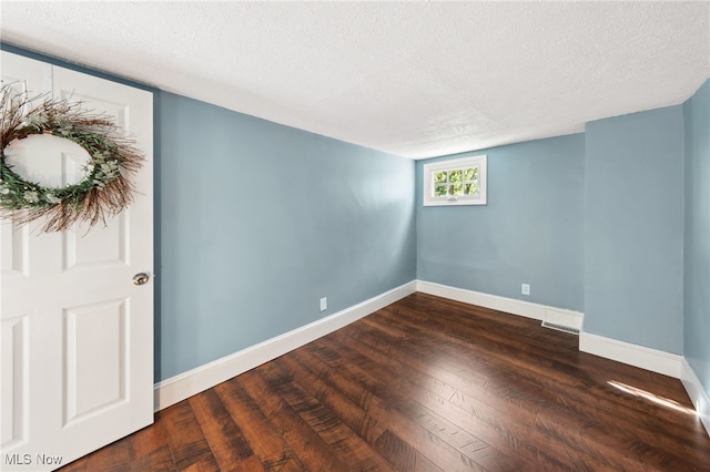 6813 W Clinton Ave, Cleveland, OH 44102 - spare room featuring a textured ceiling, dark wood finished floors, and baseboards