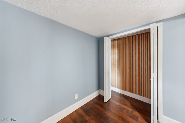 6813 W Clinton Ave, Cleveland, OH 44102 - empty room with dark wood-type flooring, baseboards, and a textured ceiling