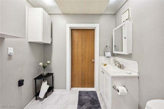 6813 W Clinton Ave, Cleveland, OH 44102 - bathroom featuring vanity, toilet, marble finish floors, and baseboards