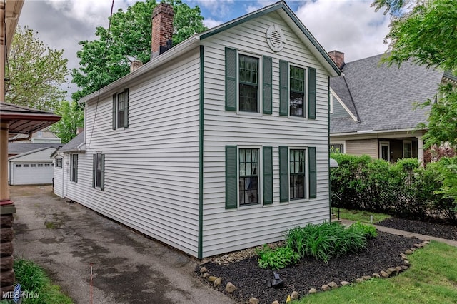 6813 W Clinton Ave, Cleveland, OH 44102 - view of home's exterior featuring a chimney, an outdoor structure, and a garage