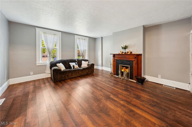 6813 W Clinton Ave, Cleveland, OH 44102 - living area with wood-type flooring, a textured ceiling, a fireplace, and baseboards