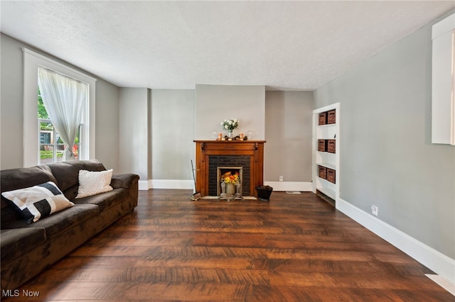6813 W Clinton Ave, Cleveland, OH 44102 - living room with wood finished floors, a brick fireplace, baseboards, and a textured ceiling