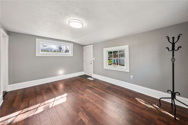 6813 W Clinton Ave, Cleveland, OH 44102 - unfurnished room with dark wood finished floors, baseboards, a textured ceiling, and vaulted ceiling