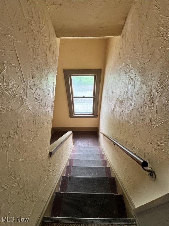 3293 E 121st St, Cleveland, OH 44120 - stairway featuring a textured wall and wood finished floors